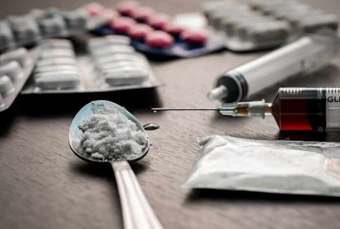 shutterstock_355085264 Spoon with white powder beside syringe and tablets