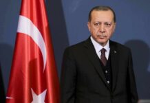 New Military Bloc Forms In Mecca man in suit standing beside Turkish flag