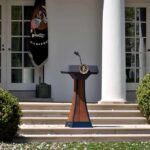 Top Cop’s Vigilance Warning Lands Hard Podium with presidential seal in a garden colonnade