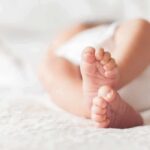 Custody Shock: Surrogate Ruled Not Mother baby feet on a soft white blanket