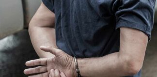person in handcuffs with hands behind back
