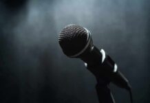 Mayor Dangles Free Concert: Public Cash For Protest Gig? Microphone on a stand against a dark blurred background