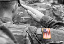 Soldier saluting with an American flag patch on sleeve