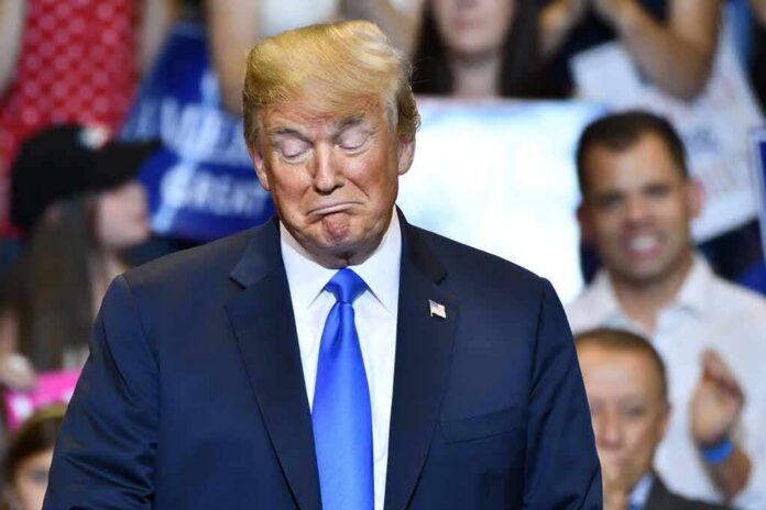 shutterstock_1361269568 Donald Trump with eyes closed and pursed lips at an event