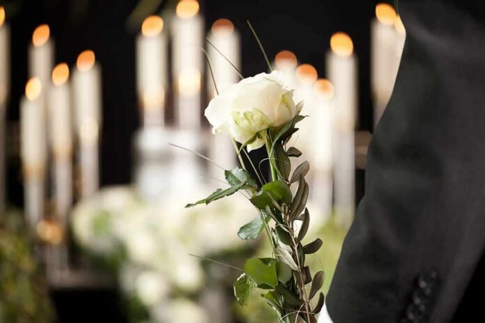 shutterstock_136792436 White rose held at a funeral
