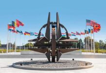 70% Rejection – Switzerland Swerves From Hard Neutrality NATO emblem sculpture surrounded by member flags