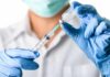 Faith Fight: Court Clash Over Kids’ Shots Explodes Healthcare worker drawing vaccine from vial with syringe