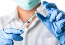 Faith Fight: Court Clash Over Kids’ Shots Explodes Healthcare worker drawing vaccine from vial with syringe