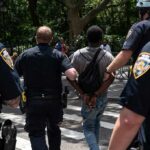 Fairground Melee Targets Governor Hopeful Police escort a handcuffed man across a city street