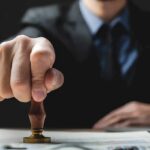 Hand stamping a document on a desk