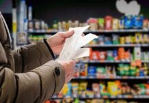 Hands holding receipts in a grocery aisle