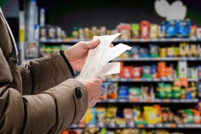 Hands holding receipts in a grocery aisle