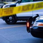 False Alert: Glitch Triggers Gunpoint Takedown Police cars behind yellow caution tape at a street scene