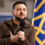 Patriot Deal Dangles – What’s Really Signed? man holding a microphone with hand on chest