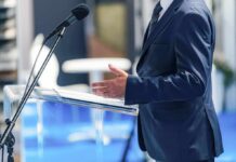 Massie Springs Shock Impeachment Vote Speaker in a suit at a podium with microphone