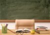 Teacher Exposed: Identity Hoax Shocks Philly Schools Teacher's desk with books, apple, and chalkboard