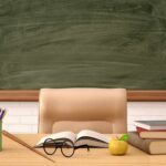 Teacher Exposed: Identity Hoax Shocks Philly Schools Teacher's desk with books, apple, and chalkboard