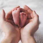 Baby Can’t Wait – Street-Side Delivery Adult hands cradling newborn baby feet