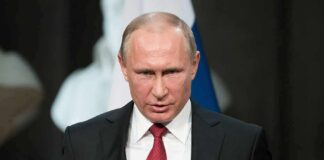 Vladimir Putin speaking at a podium with a microphone