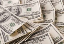 Yields Spike – 5% Line Breaks: Mortgages Next? Stacks of US $100 bills scattered