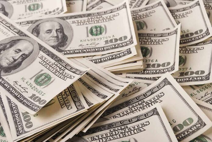 shutterstock_696138958 Stacks of US $100 bills scattered
