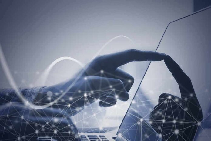 shutterstock_735977854 Hand touching a tablet screen with abstract network overlay