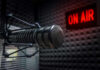 Microphone in soundproof studio with On Air sign.