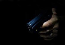 Hand holding a handgun in low light
