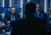 Hunter Laptop Twist: Who Rigged The Story? Business professionals in a dim conference room meeting