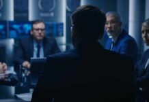 Business professionals in a dim conference room meeting