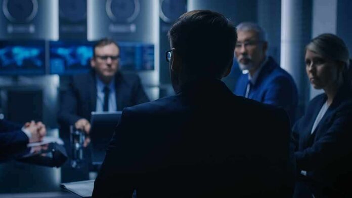Business professionals in a dim conference room meeting