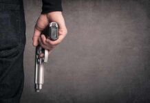hand holding a handgun at side