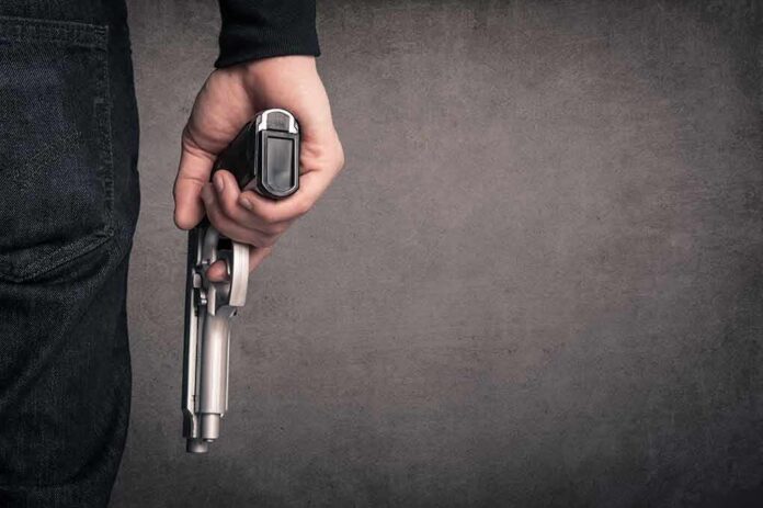 hand holding a handgun at side
