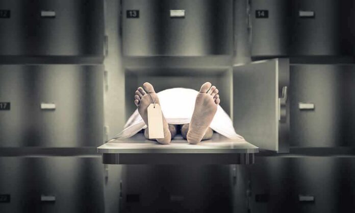 shutterstock_1279100890 Body on morgue tray with toe tag and sheet