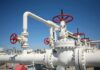 Sabotage Blast Cripples Syria’s Grid Industrial pipeline with red valves against a clear blue sky