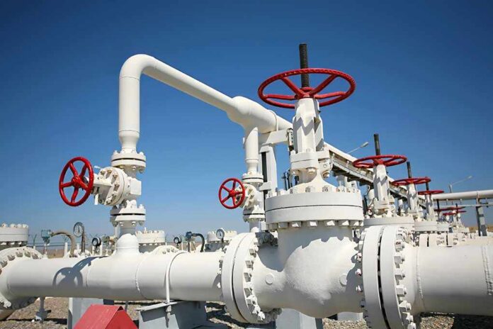 Industrial pipeline with red valves against a clear blue sky