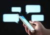 Discord Plot Ties American To BC Massacre Hand holding smartphone with chat bubbles on dark background