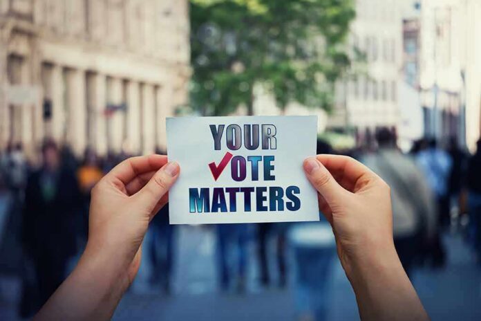 Hands holding a sign about voting in a busy city street