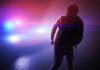 Actor Beaten and Robbed – Caught on Tape silhouetted person in front of police car with flashing lights
