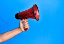 Hypocrisy Bomb Hits ‘Protect Kids’ Ad Hand holding a red megaphone against a blue background