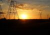 Transmission towers at sunset with power lines