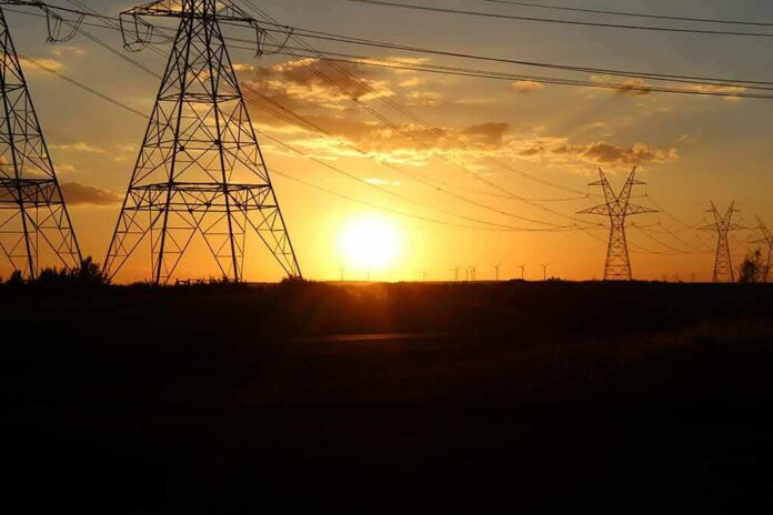 shutterstock_1935182081 Transmission towers at sunset with power lines