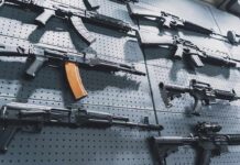 Assault rifles displayed on a perforated wall