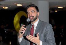 Zohran Mamdani speaking into a microphone