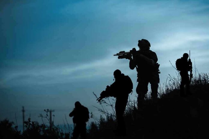 Silhouetted soldiers patrolling a hillside at dusk
