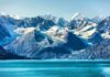 Snow-capped mountains with glaciers above a turquoise lake
