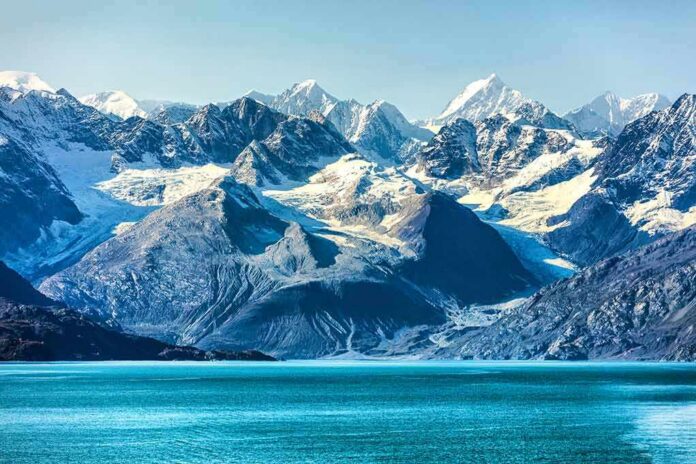 Snow-capped mountains with glaciers above a turquoise lake