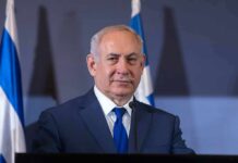 Netanyahu Pushes War, Top General Pushes Back man in suit at podium with microphones