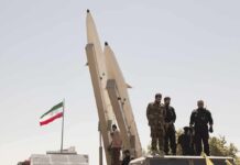 Iran Missiles Rebound – Gulf On Notice Soldiers stand beside large missiles at an outdoor display
