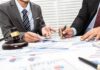 Getty Goes Dark – Family Reclaims It All Two businesspeople in suits reviewing charts at a desk with a gavel